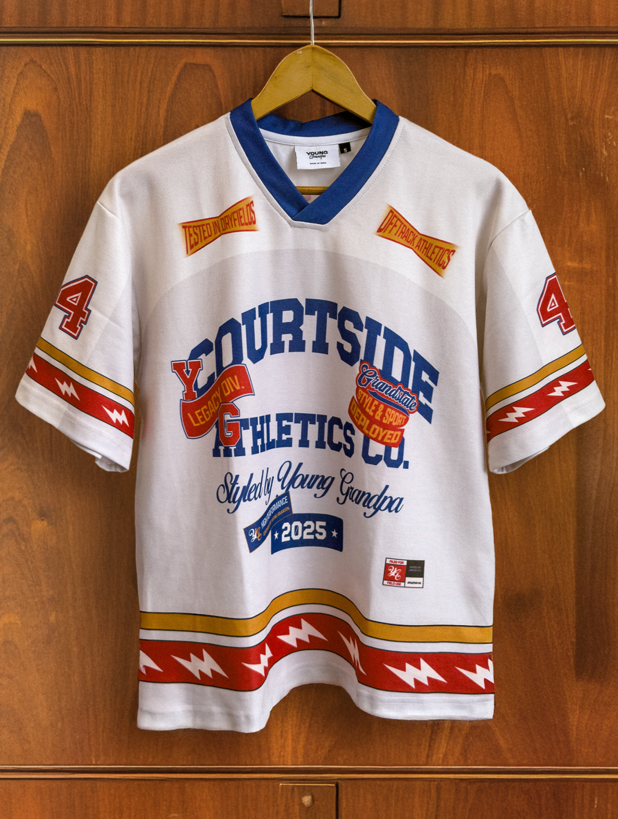 White sports jersey with colorful text and graphics on a wooden wardrobe background